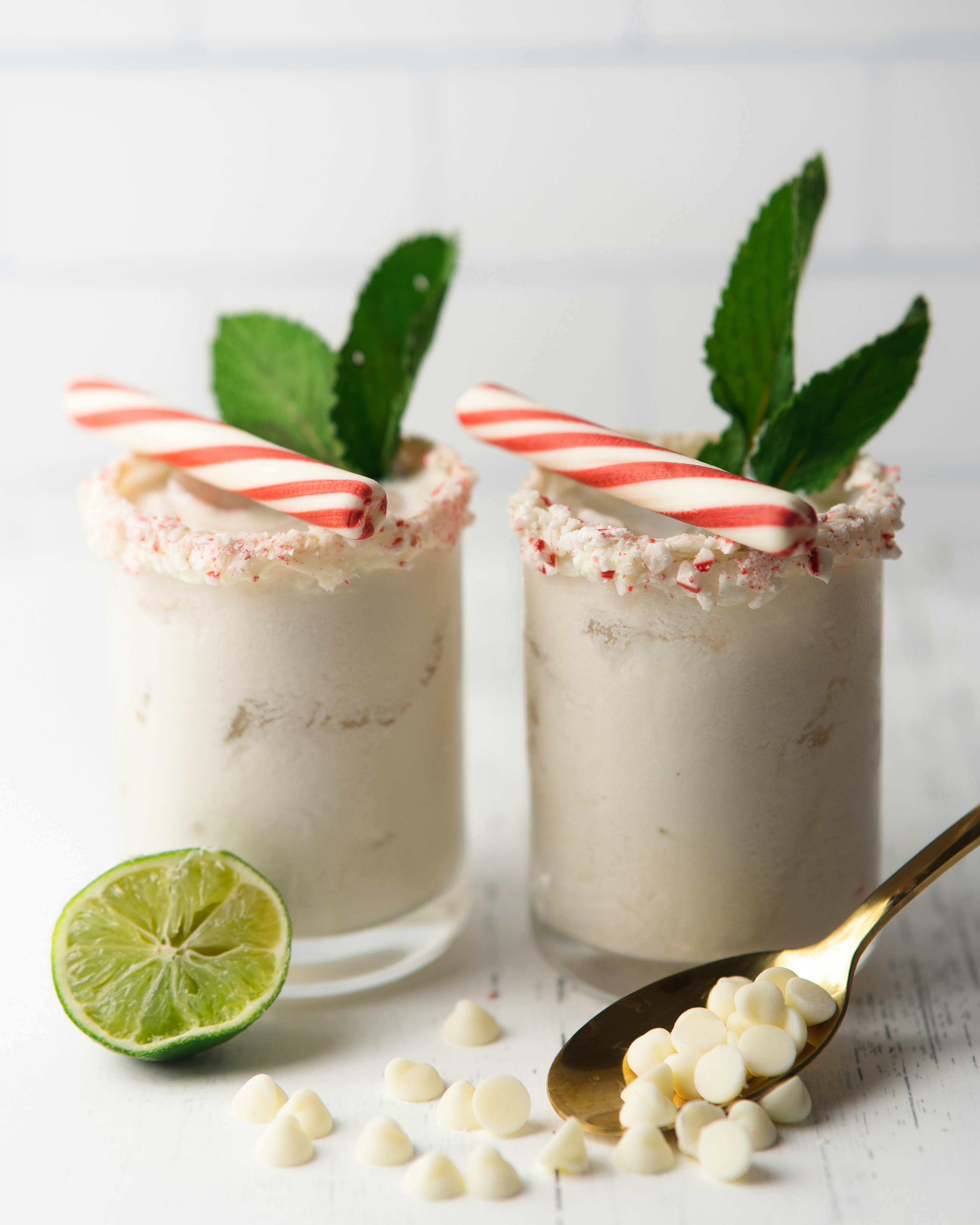 two clear drinking glasses with white liquid and sliced lemon